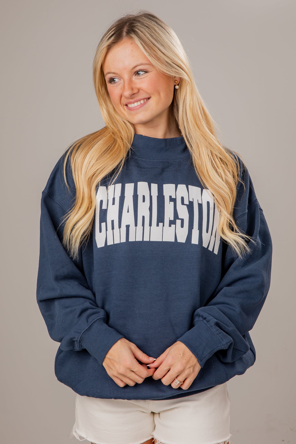 Woman wearing a navy blue sweatshirt with &