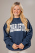 Woman wearing a navy blue mockneck sweatshirt with &