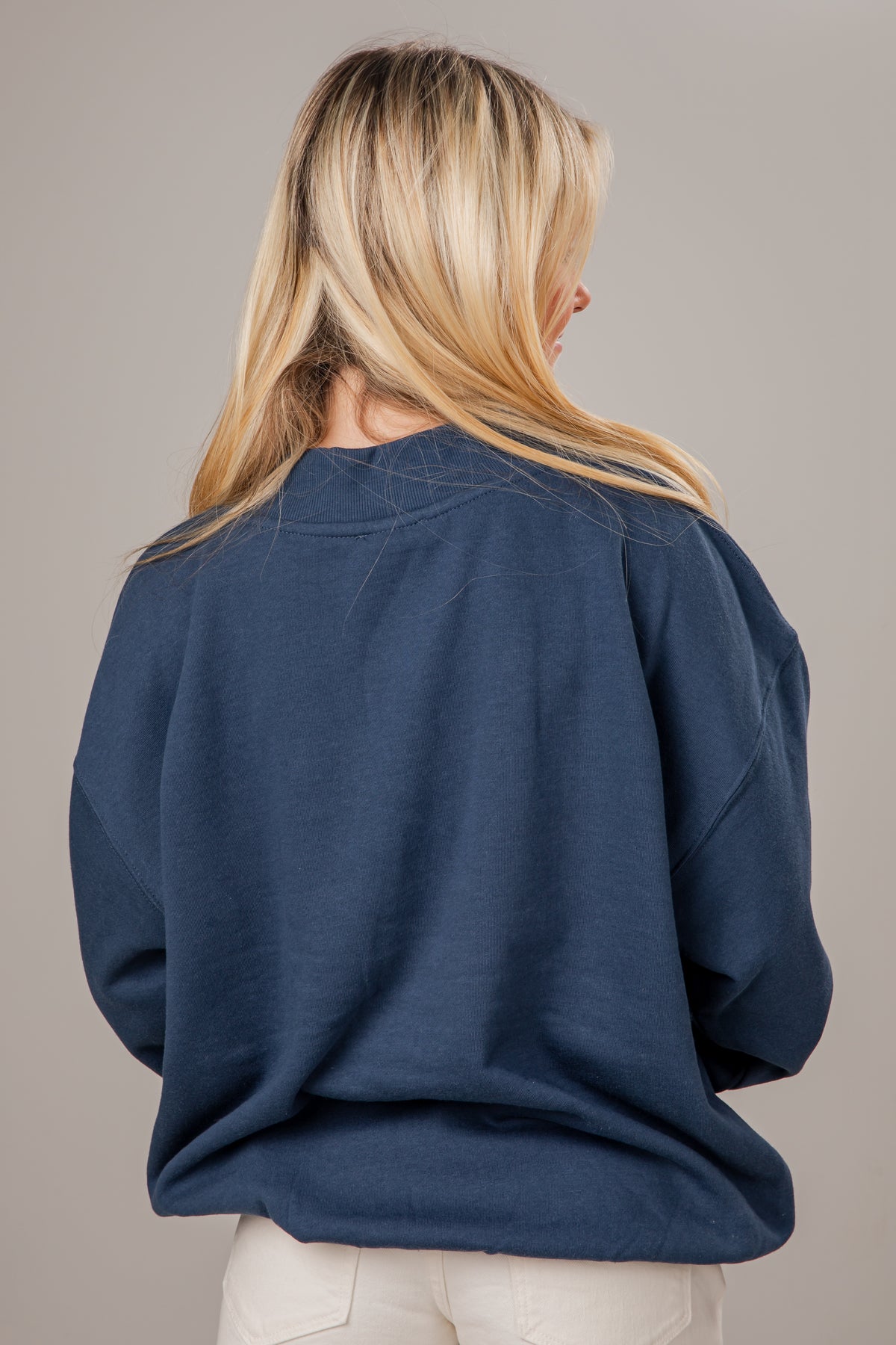 Person wearing a blue mock neck on a plain background