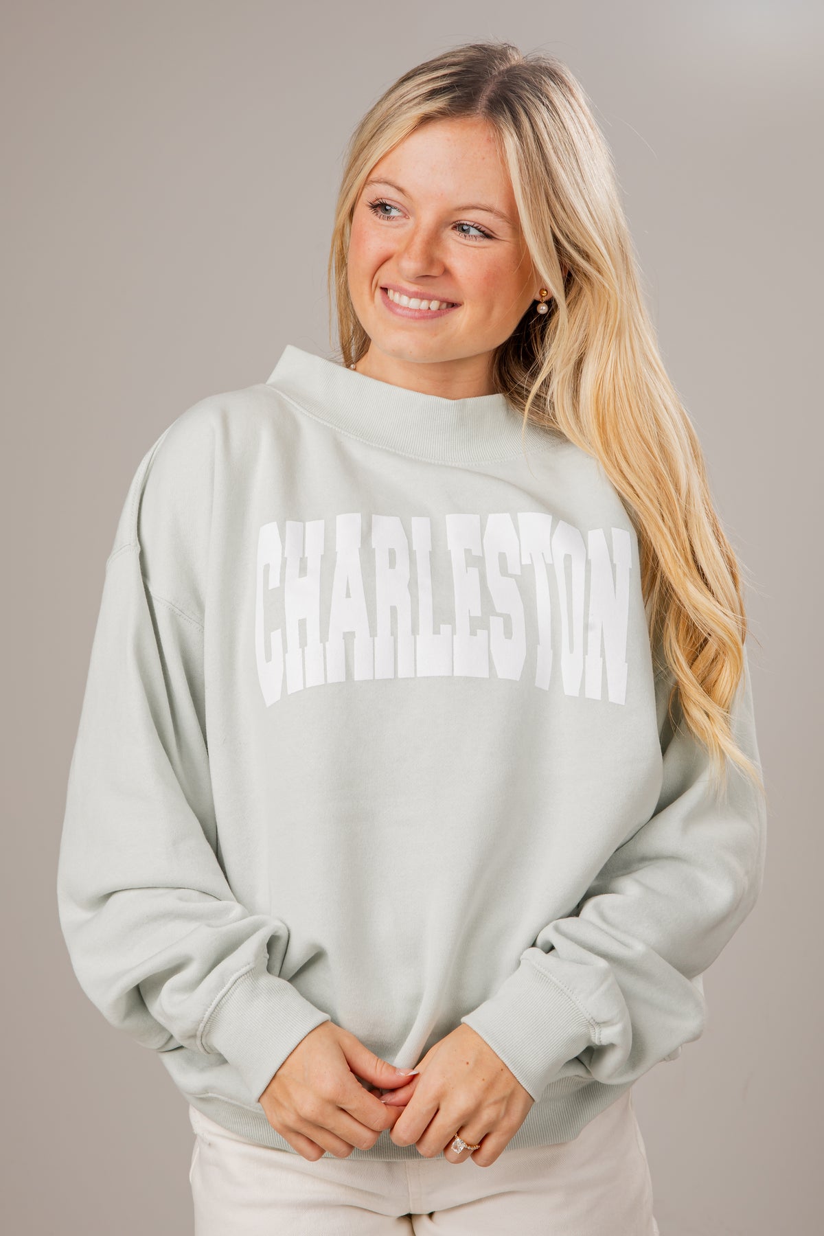 Woman wearing a light sage sweatshirt with &
