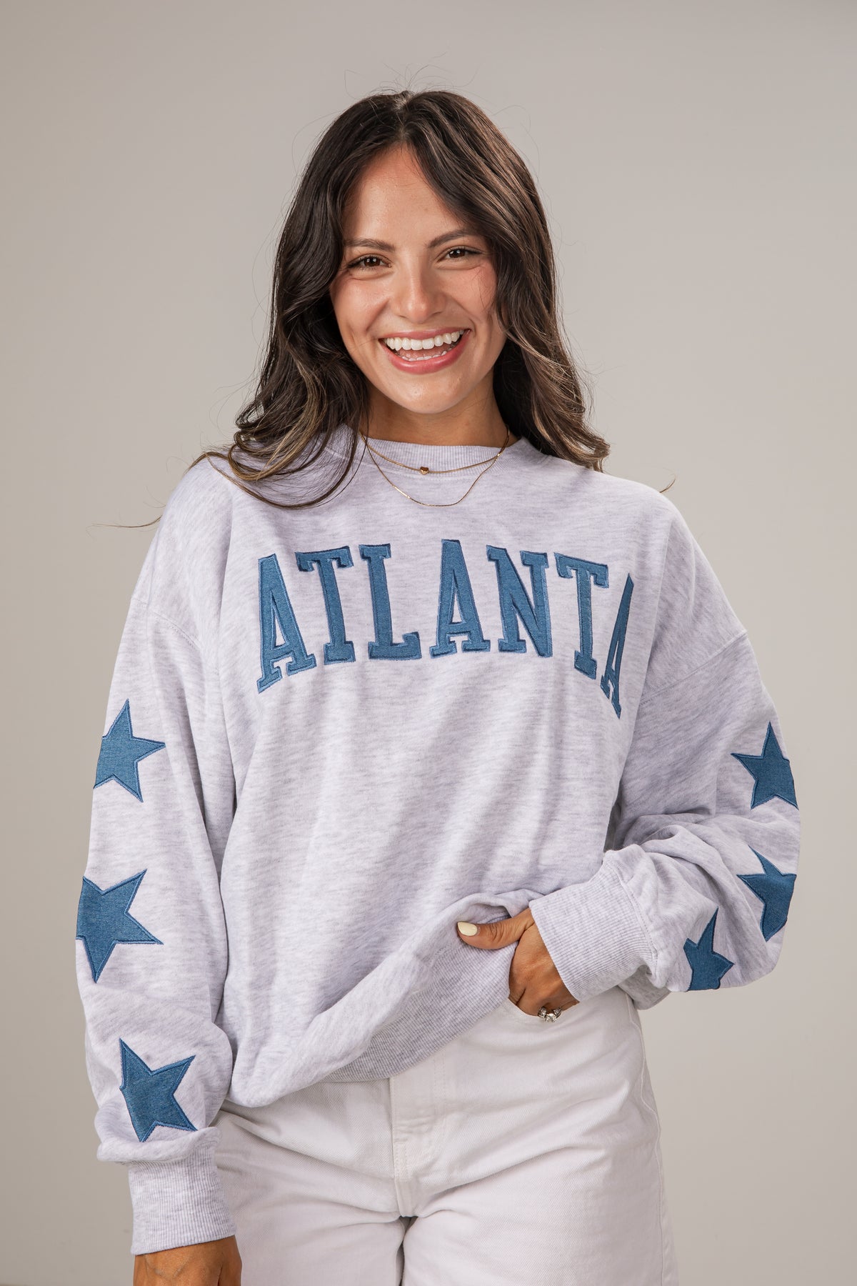 Woman wearing a gray sweatshirt with &