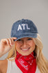 Person wearing a denim cap with &