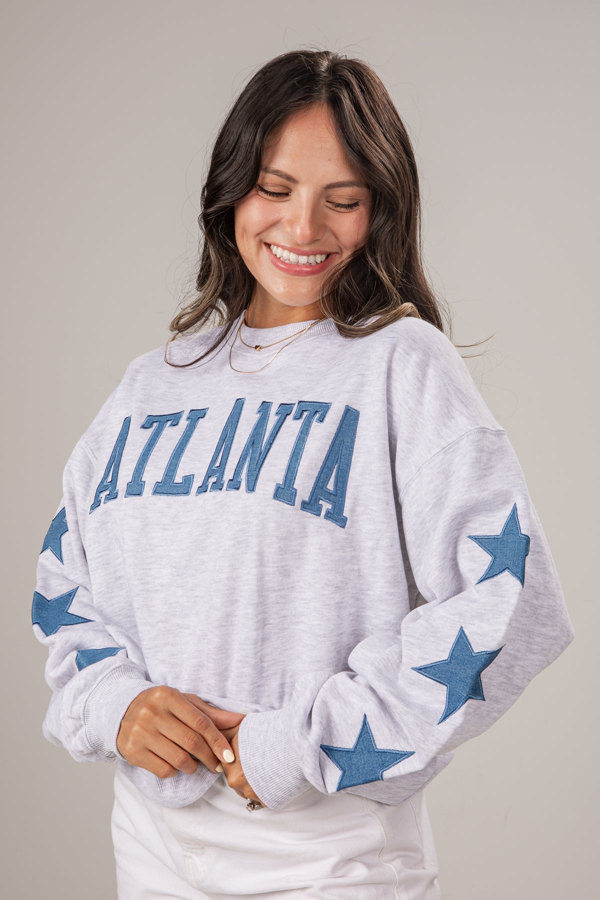 Woman wearing a white sweatshirt with &