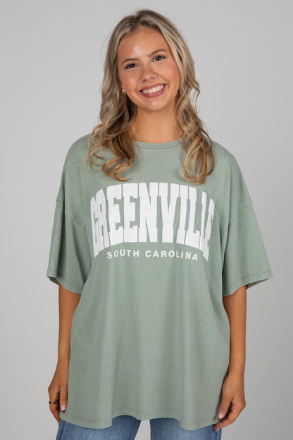 Woman wearing a green t-shirt with &