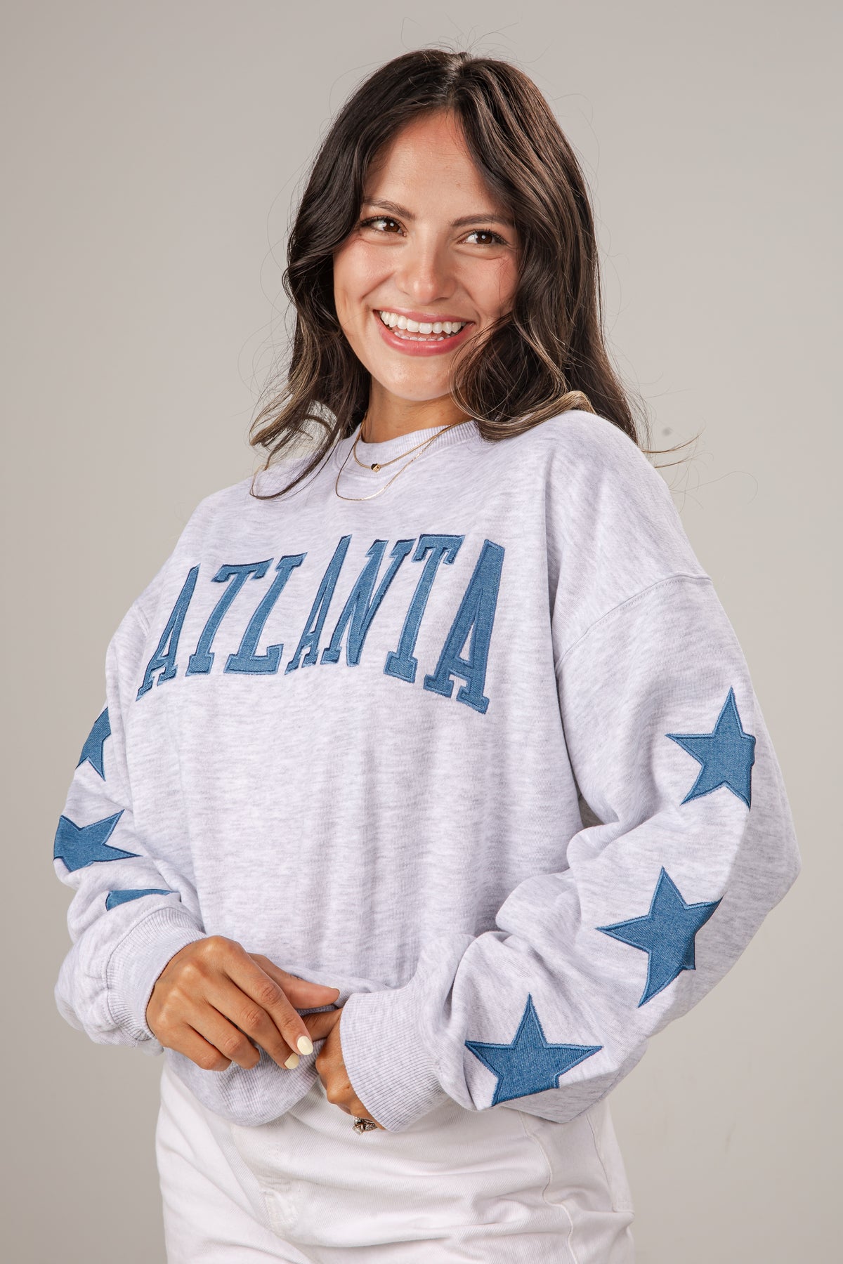 Woman wearing a gray sweatshirt with &