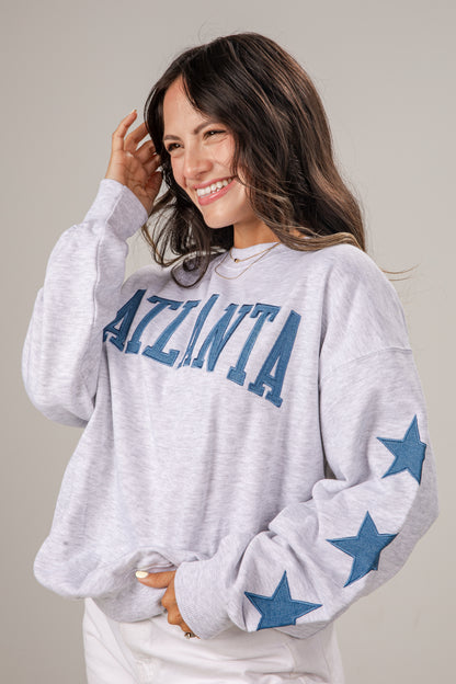 Woman wearing a gray sweatshirt with &