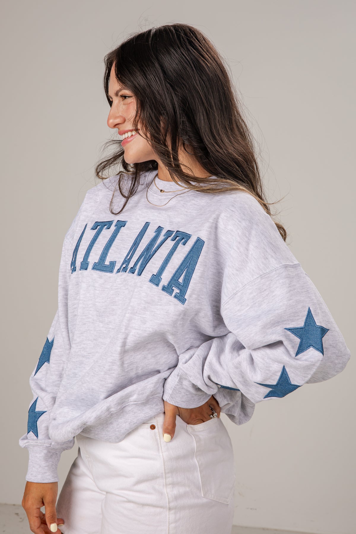 Woman wearing a gray sweatshirt with &