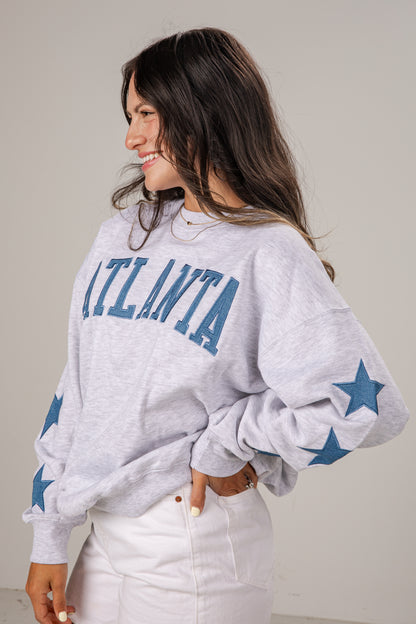 Woman wearing a gray sweatshirt with &