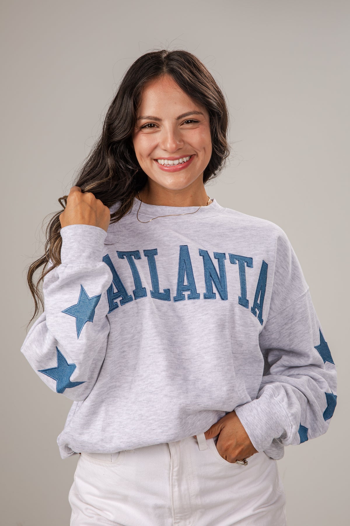 Woman wearing a gray sweatshirt with &