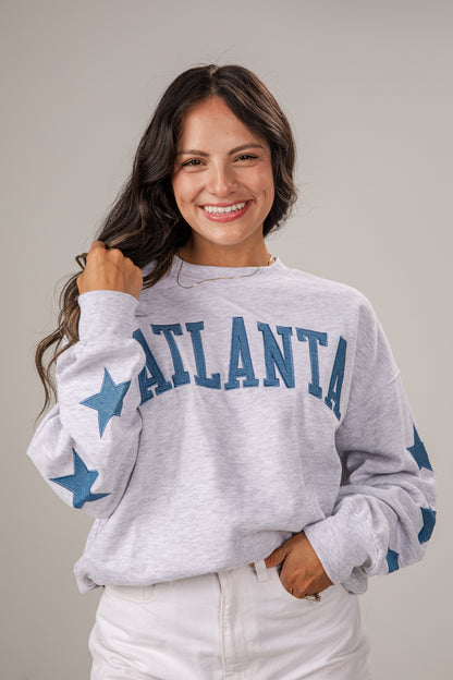 Woman wearing a gray sweatshirt with &