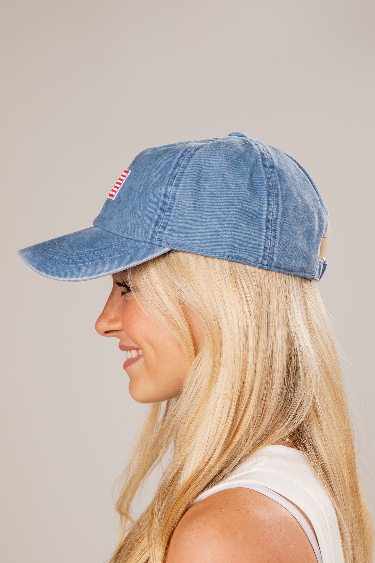Woman wearing a denim cap on a plain background