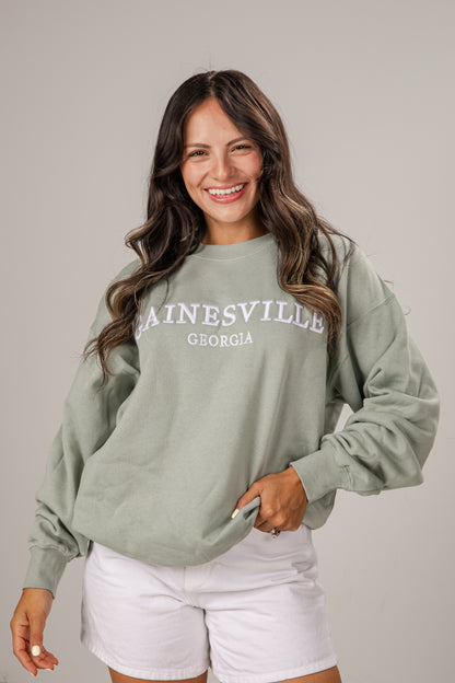 Woman wearing a green sweatshirt with &