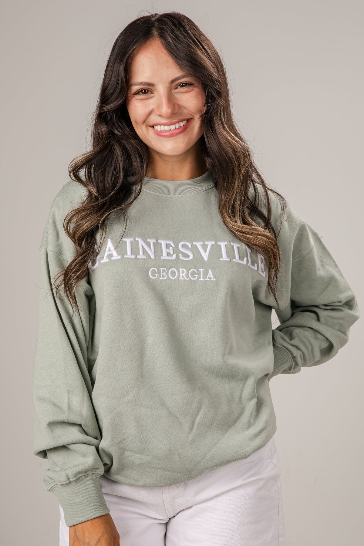 Woman wearing a green sweatshirt with &