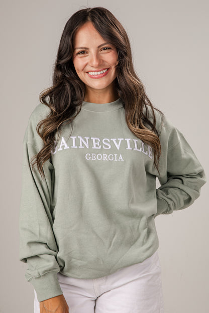 Woman wearing a green sweatshirt with &