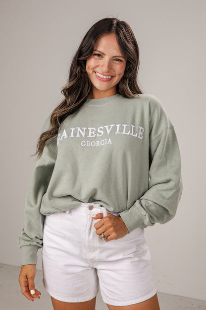 Woman wearing a green sweatshirt with &