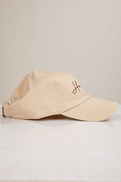 Beige cap with a logo on a light gray background