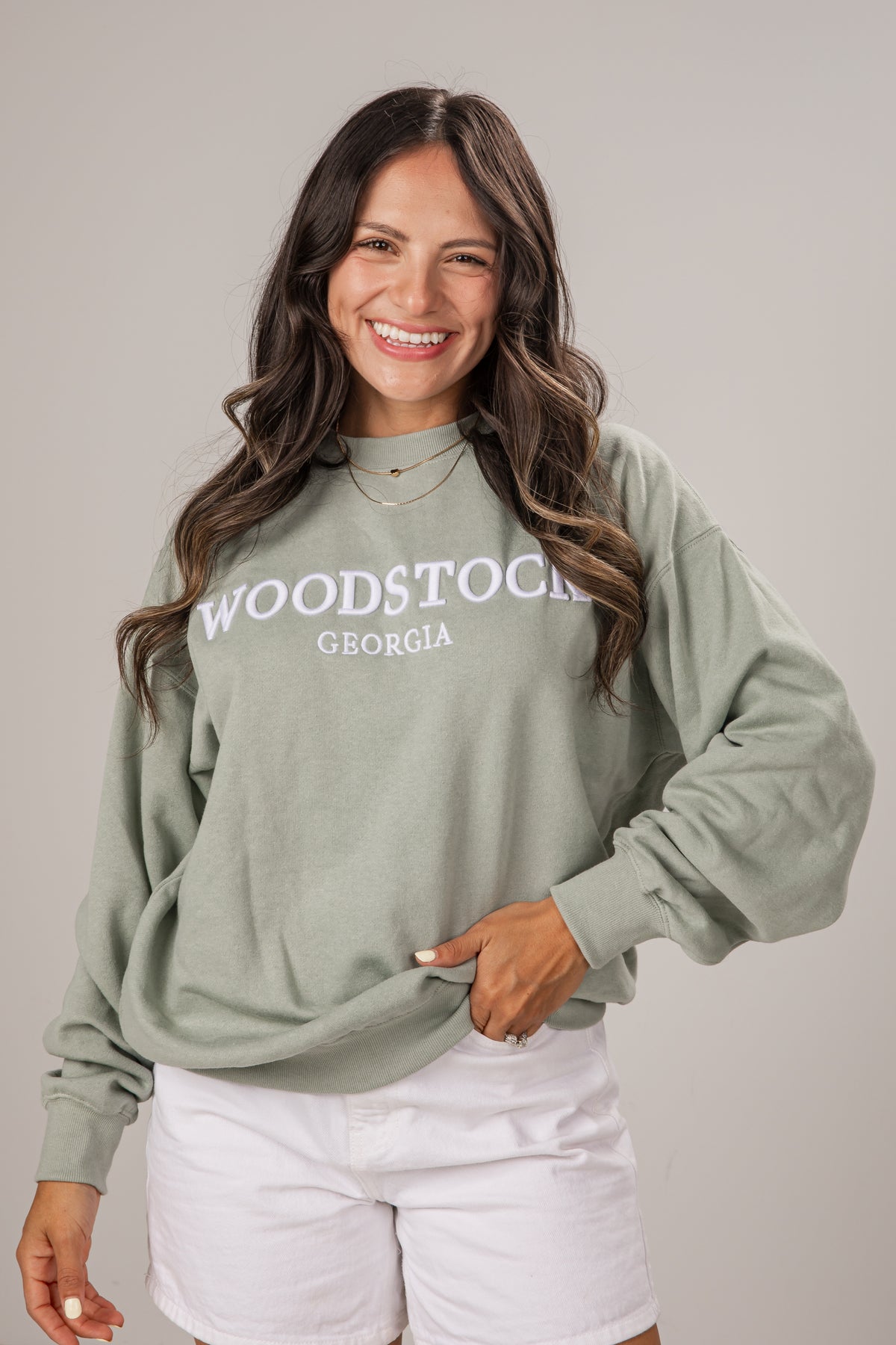 Woman wearing a green sweatshirt with &