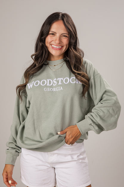 Woman wearing a green sweatshirt with &