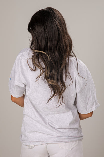Person wearing a gray t-shirt with a plain background