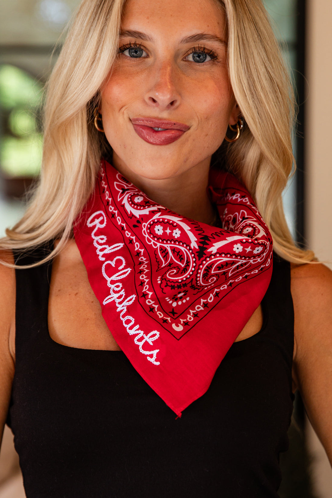 Woman wearing a red bandana with &