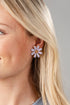 Close-up of a woman wearing a floral earring with a plain background