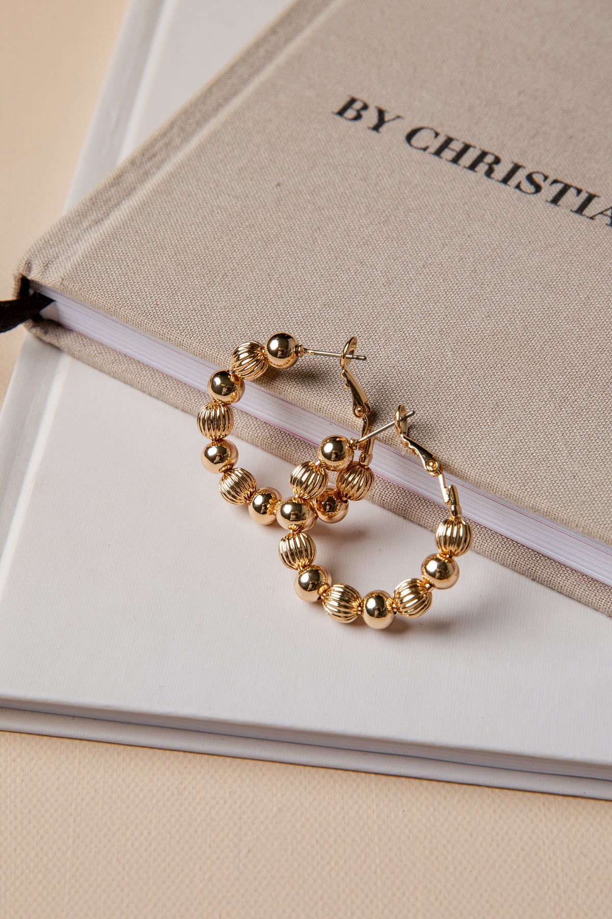 Gold hoop earrings on a book with &
