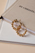 Gold hoop earrings on a book with &