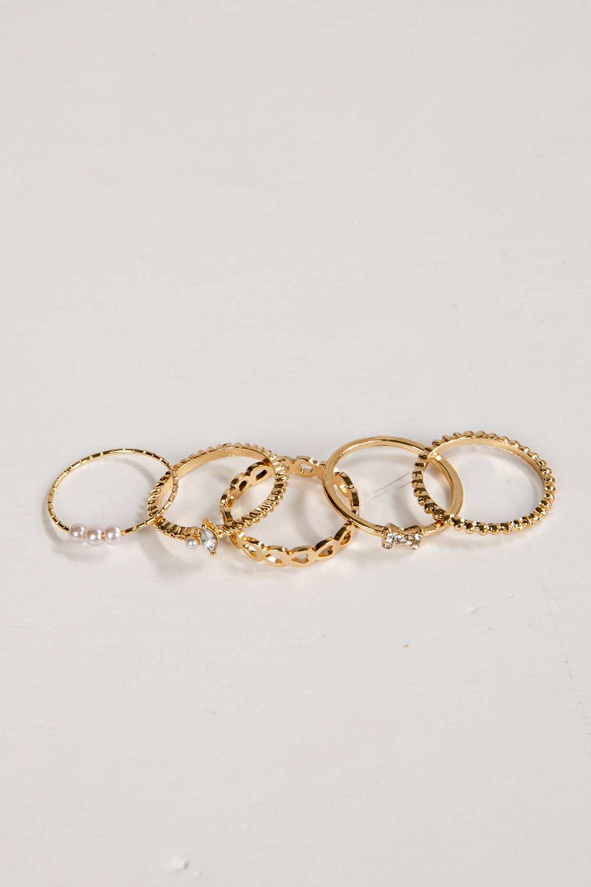 Set of gold rings on a light gray background