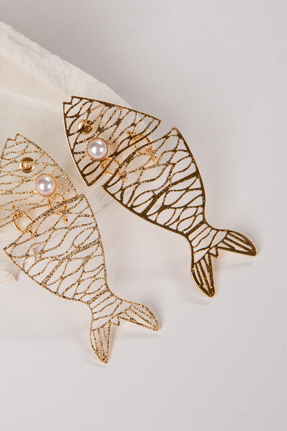 Gold fish-shaped earrings with pearl accents on a light background