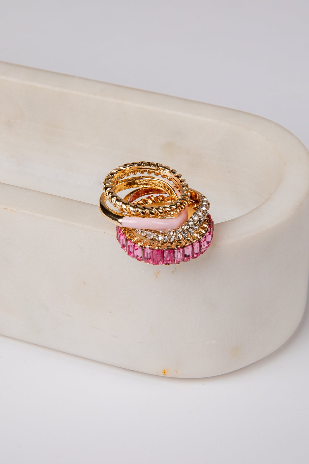 Gold and pink ring on a white surface