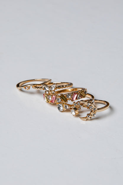 Gold rings with gemstones on a light gray background