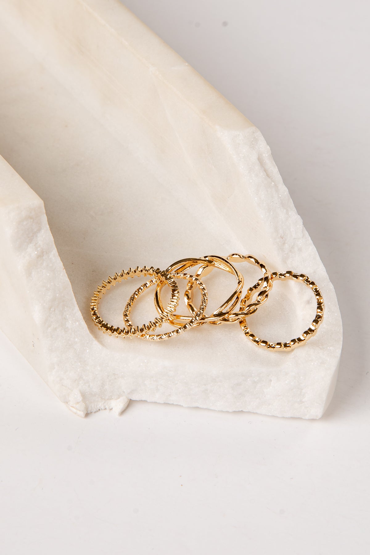 Gold rings on a white fabric surface