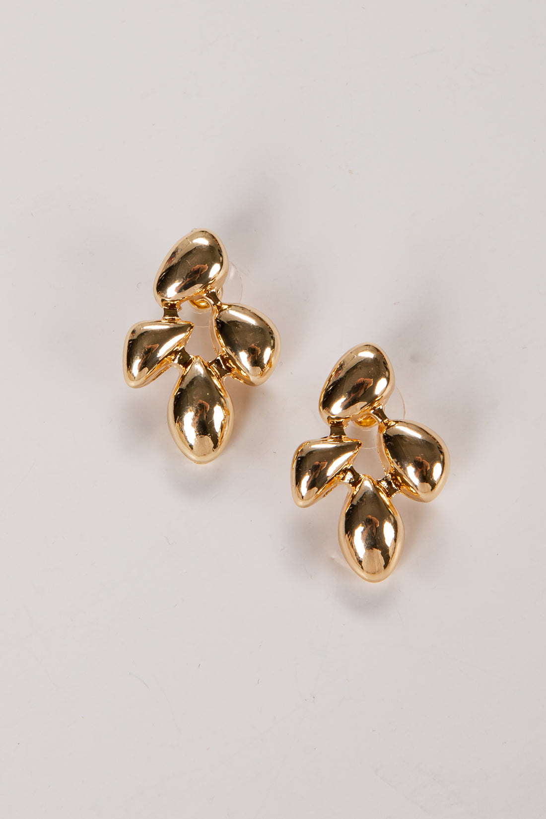 Pair of gold earrings on a light gray background