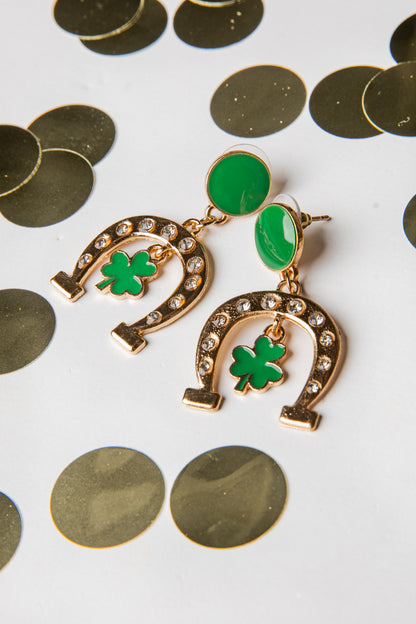 Gold earrings with green shamrock designs on a white background with gold coins.