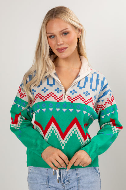 Woman wearing a colorful patterned sweater against a plain background