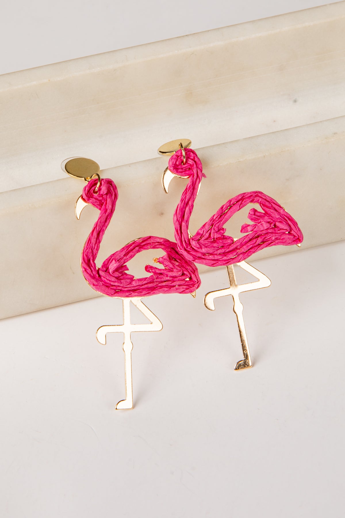 Flamingo-shaped earrings on a light background