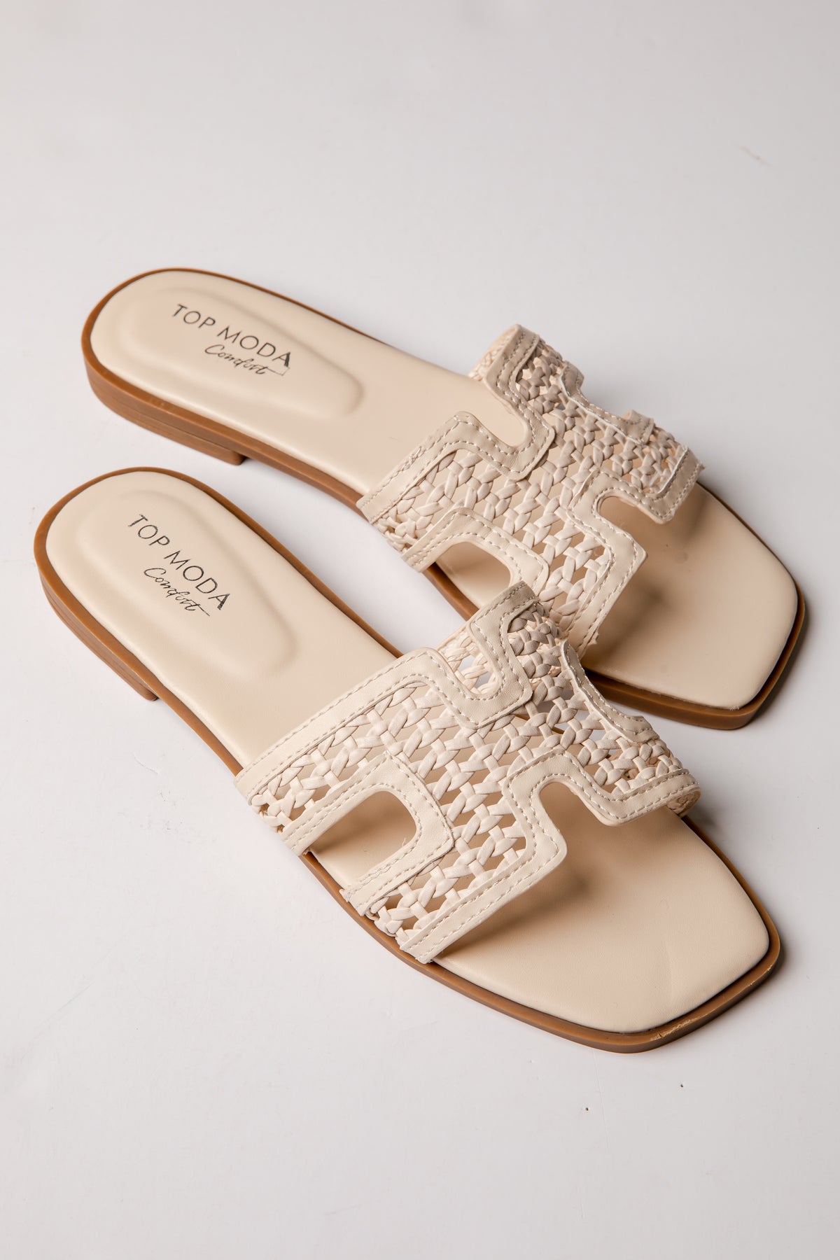 Beige sandals with crochet details on a white background