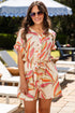 Woman wearing a colorful dress with sunglasses in an outdoor setting