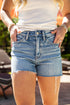 Person wearing denim shorts with a blurred outdoor background