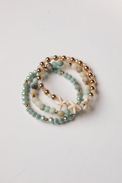 Set of beaded bracelets with starfish charm on a light background