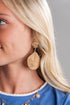 Close-up of a woman wearing gold earrings with a blurred background