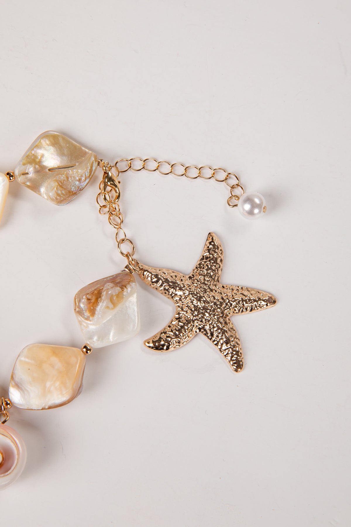 Bracelet with starfish and shell charm on a light background