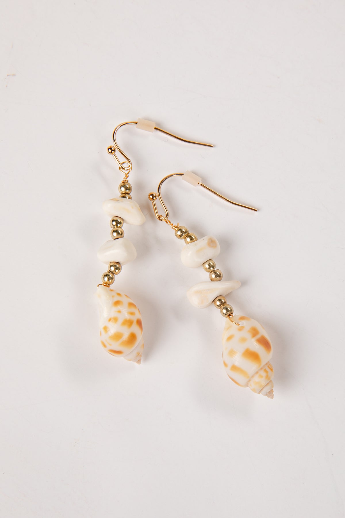 Shell earrings with gold accents on a white background