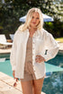 Woman wearing a white shirt and checkered shorts by a poolside