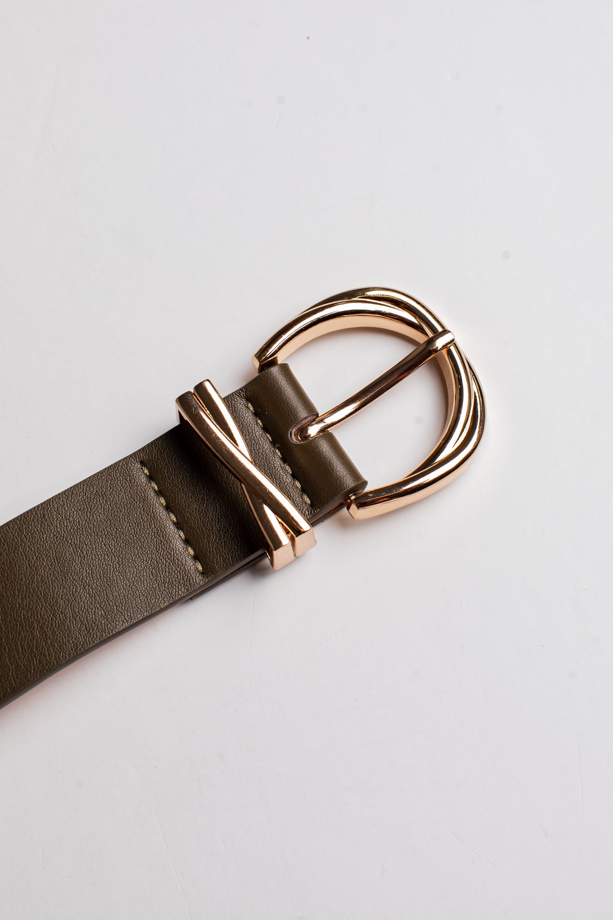 A close-up of a dark brown leather belt with a polished rose gold buckle, shown on a clean white background.