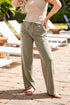 Woman wearing light green pants and a beige top on a patio