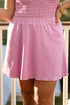 Person wearing a pink strapless dress on a balcony with blurred background