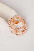 Set of beaded bracelets with peach and gold colors on a white surface