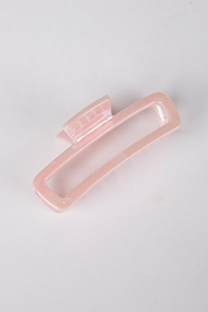 Pink hair clip on a light gray background