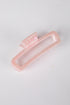 Pink hair clip on a light gray background